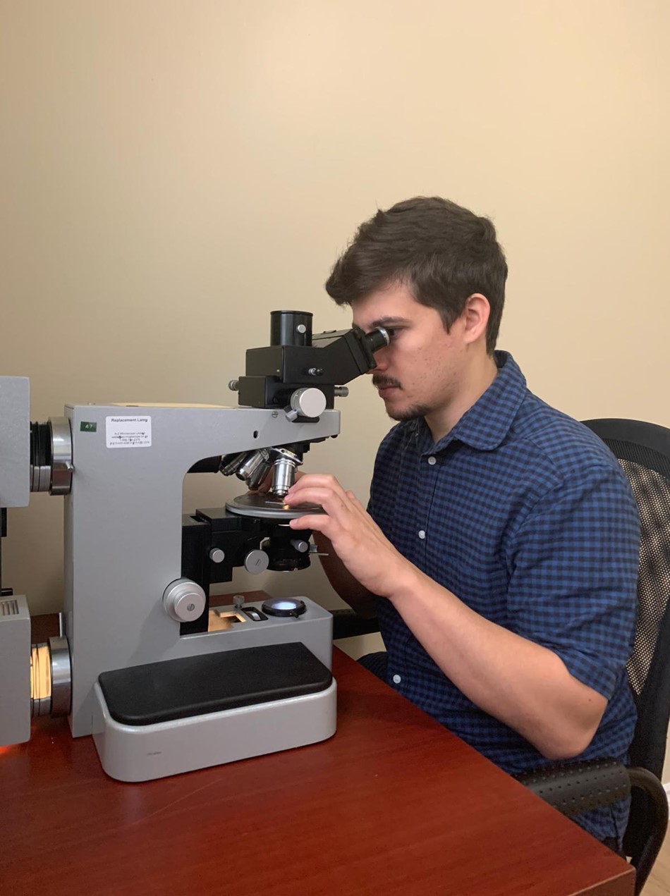 Klaus Kuster studying thin sections from the Shebandowan area (photo by B Kuster)